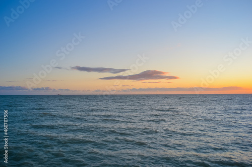 Sea at sunset, clear sky and light waves