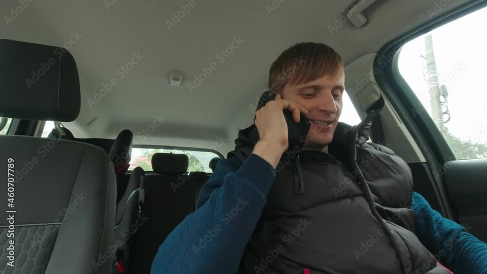 Smiling man talking on the phone in the car Smiling man talking on the phone in the car