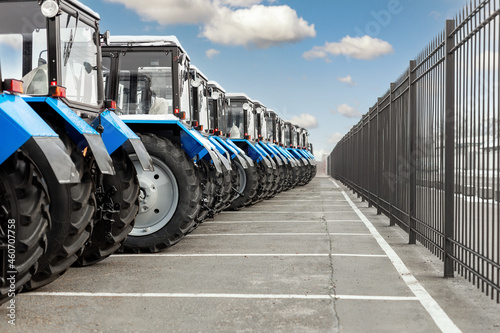 Fotografie Many different tractors standing in row at agricultural fair for sale outdoors