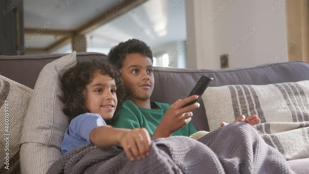 Slow motion of two boys watching TV with remote control Slow motion of two boys watching TV with remote control