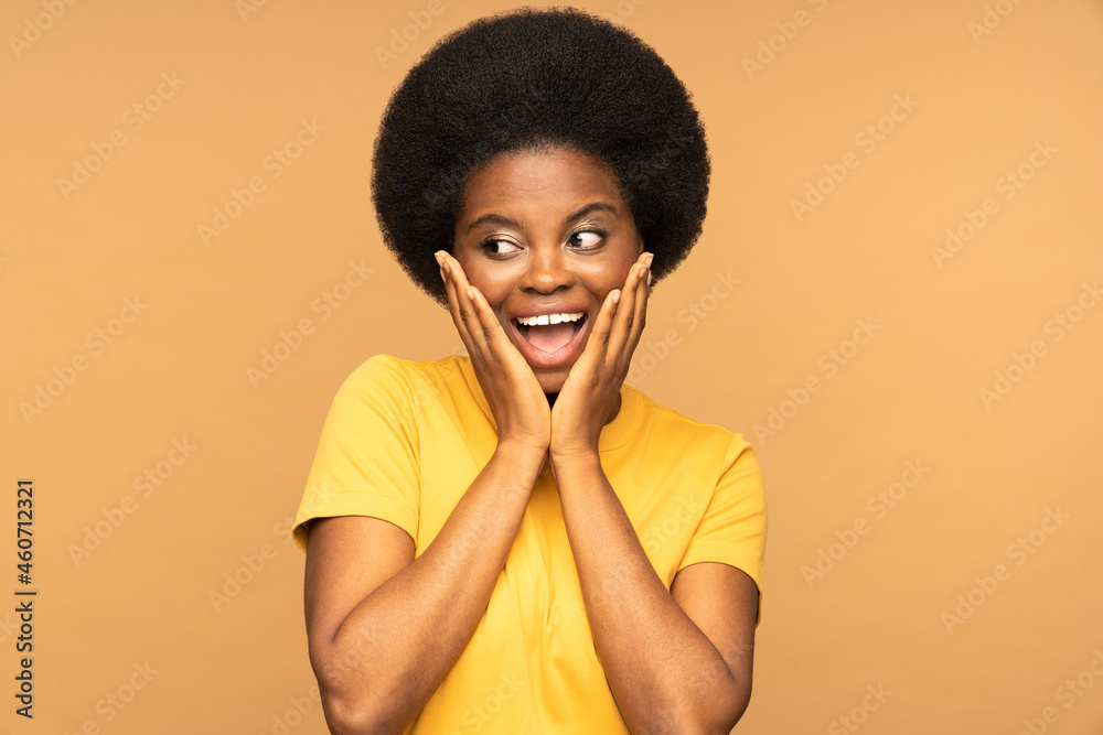 Excited surprised african woman emotional looking aside with open mouth screaming from excitement. Young black female staring at empty copy space for advertising with happy shocked look touch cheeks Excited surprised african woman emotional looking aside with open mouth screaming from excitement. Young black female staring at empty copy space for advertising with happy shocked look touch cheeks
