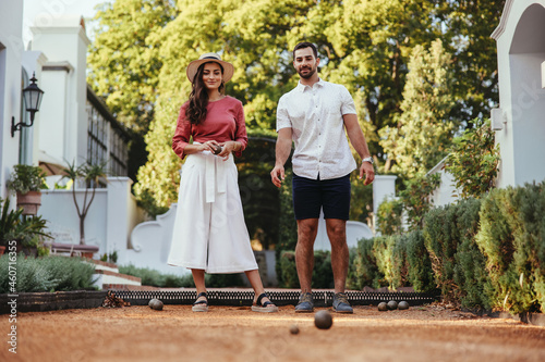 Young tourist couple playing boules at a hotel photo