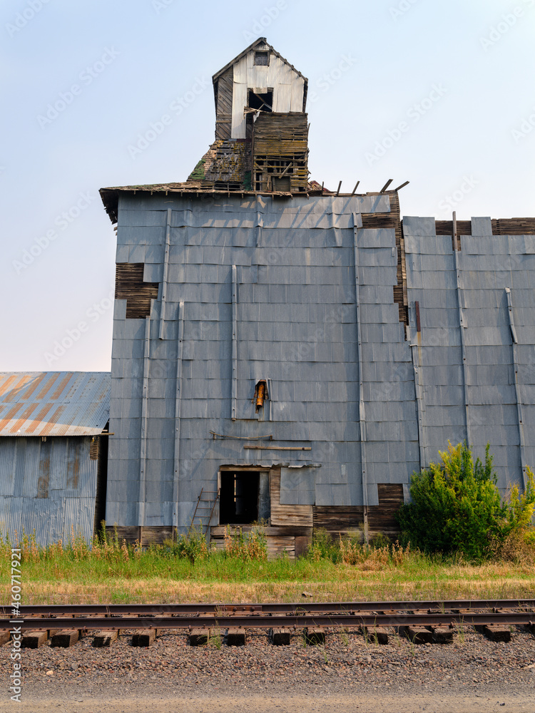 Railroad tracks run behind an abandoned grain elevator in southeastern Washington, USA