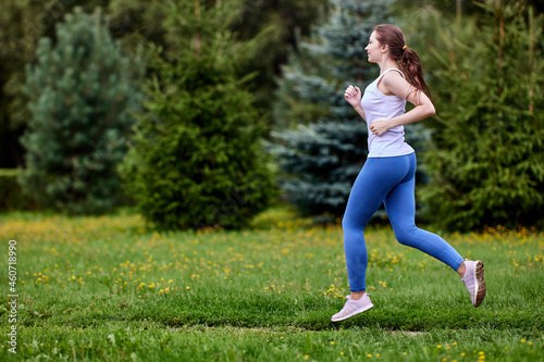 White woman is training in park in leggins. © grigvovan
