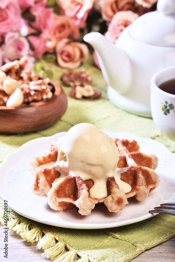 Plate of belgian waffles with ice cream on wooden table Plate of belgian waffles with ice cream on wooden table