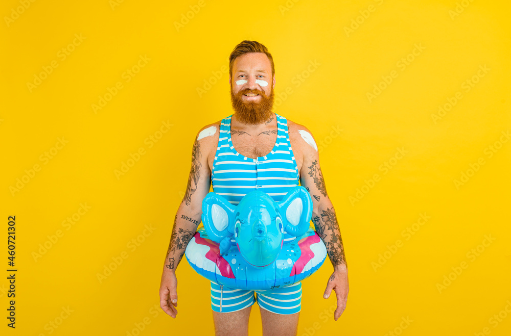 Happy man with inflatable donut with elephant is ready to swim Happy man with inflatable donut with elephant is ready to swim