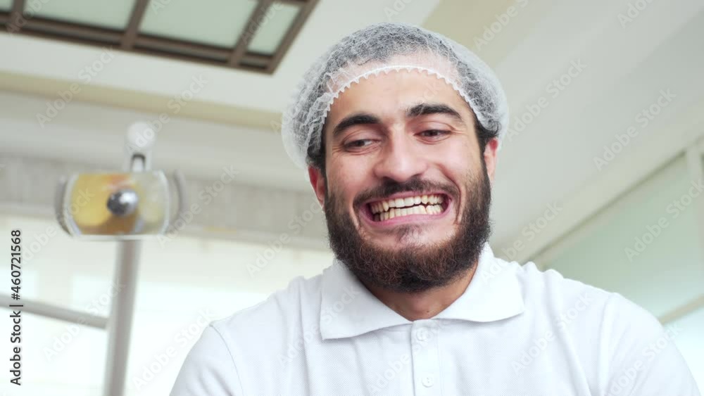 A bearded dentist is showing a patient how to show their theeth and raising hands with diagnostic instruments. POV. Funny doctor. Oral hygiene and dental cure in dentistry A bearded dentist is showing a patient how to show their theeth and raising hands with diagnostic instruments. POV. Funny doctor. Oral hygiene and dental cure in dentistry