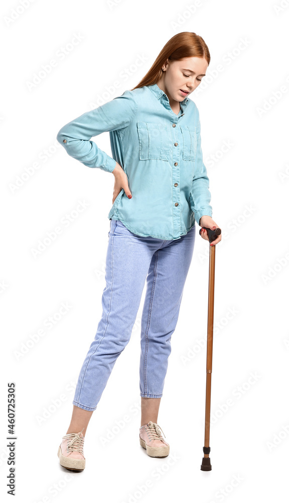 Sick young woman with walking stick suffering from back pain on white background Sick young woman with walking stick suffering from back pain on white background
