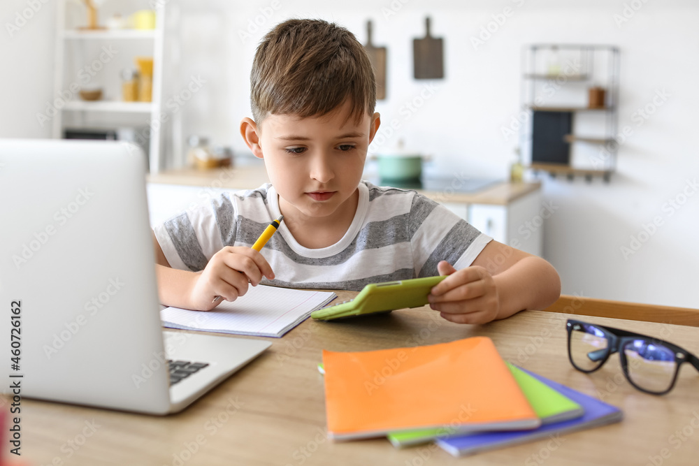 Little boy doing homework in room Little boy doing homework in room