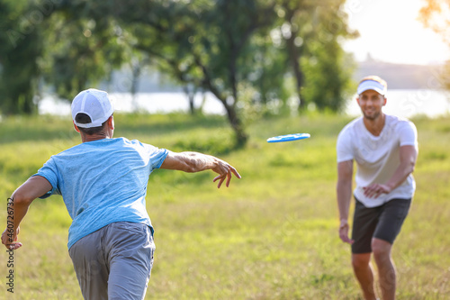 Young men playing frisbee in park photo