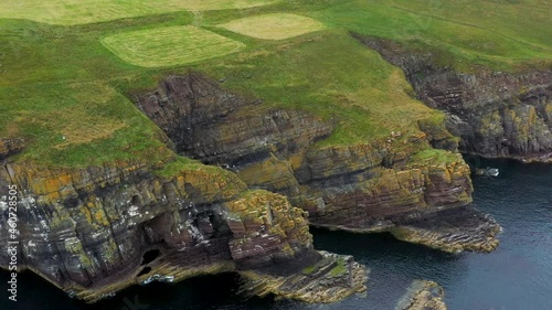 Cinematic drone shot of Whaligoe Haven revealing the rocky 250ft cliffs overlooking the north sea in Scotland photo