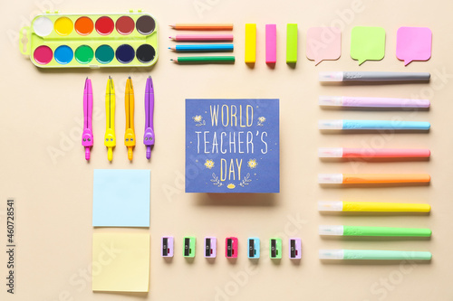 Concept of Teacher's Day. School supplies and greeting card on color background, top view