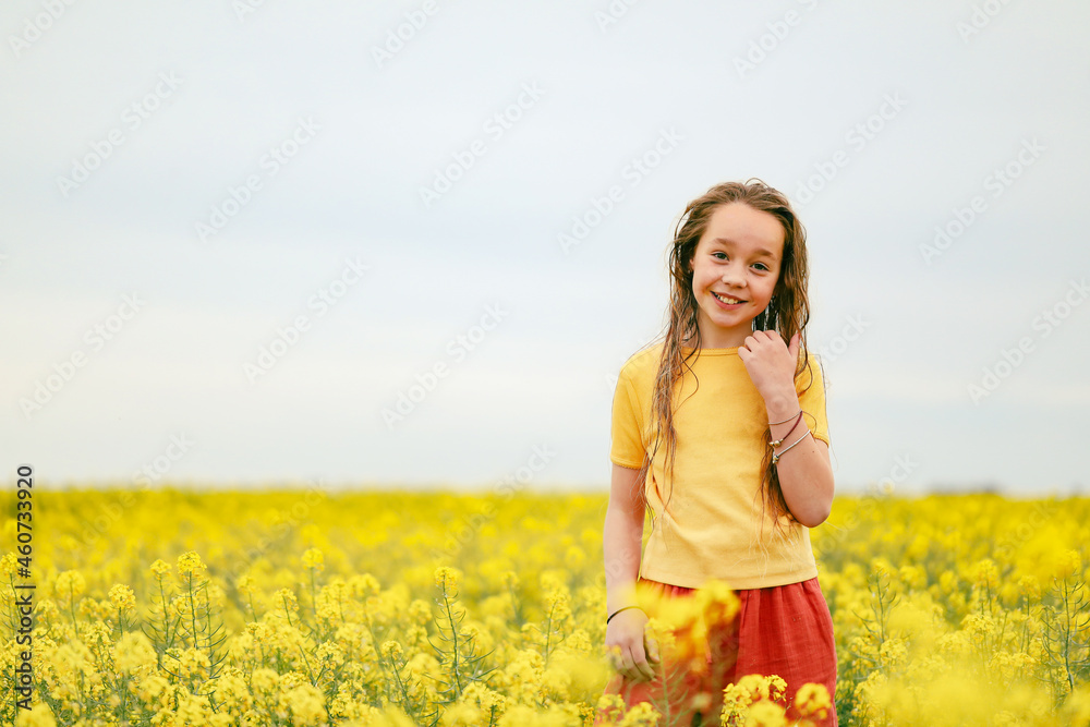 Pretty long haired girl playing in vibrant canola field in full bloom Pretty long haired girl playing in vibrant canola field in full bloom