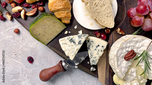 Assorted cheeses on wooden board.
