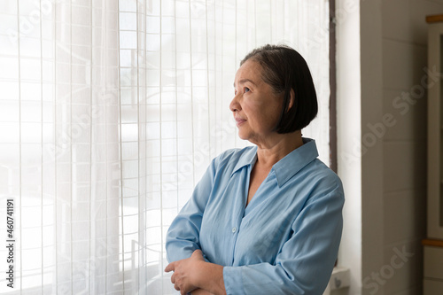 Free Download Elderly Asian woman standing and having a headache and touching her head with her hands at home. Asian older lonely woman. Retirement, quarantine and health care concept - GFXLoad
