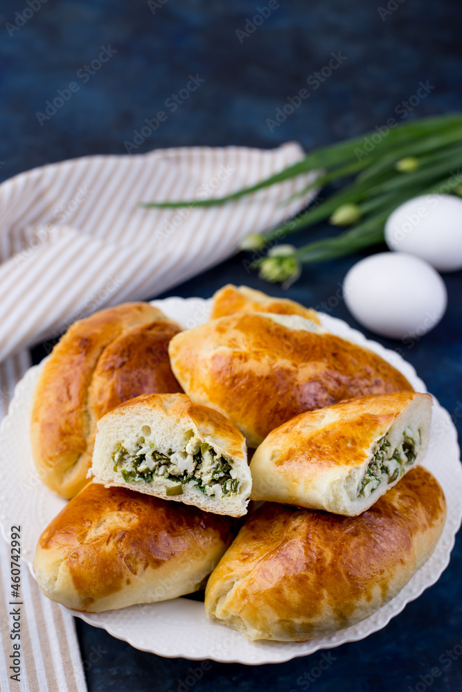 Delicious little pies with green onion and egg. Traditional Russian cuisine. Homemade cakes.