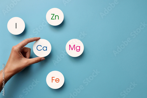 paper circles with inscriptions of vitamins and macronutrients. Choosing calcium from other useful substances photo