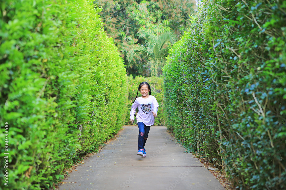 Asian child girl running in garden Maze. Kid playing in labyrinth for fun and entertainment. Back view. Asian child girl running in garden Maze. Kid playing in labyrinth for fun and entertainment. Back view.