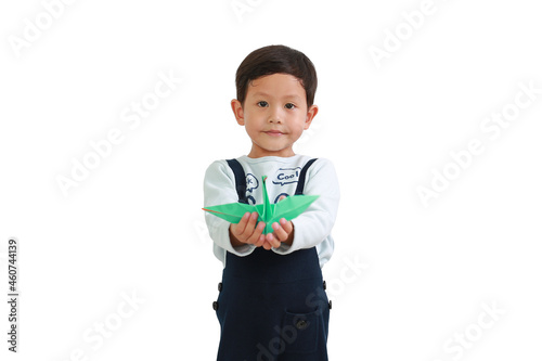 Little Asian boy holding origami bird isolated on white background. Focus at baby face. Freedom concept