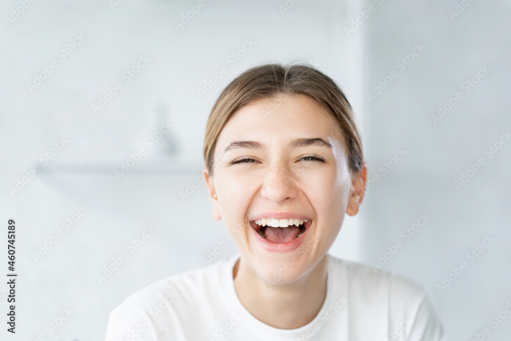 Laughing woman. Dental care. Beauty wellness. Joyful smiling model with fresh radiant face skin on light defocused bathroom background. Laughing woman. Dental care. Beauty wellness. Joyful smiling model with fresh radiant face skin on light defocused bathroom background.