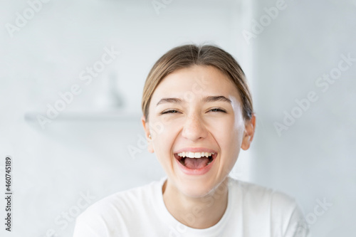 Laughing woman. Dental care. Beauty wellness. Joyful smiling model with fresh radiant face skin on light defocused bathroom background.