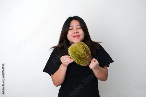 Adult Asian woman showing in love expression while smelling a durian fruit photo