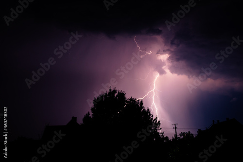 Multiple lightning strikes painting the sky purple on a summer evening during a thunderstorm