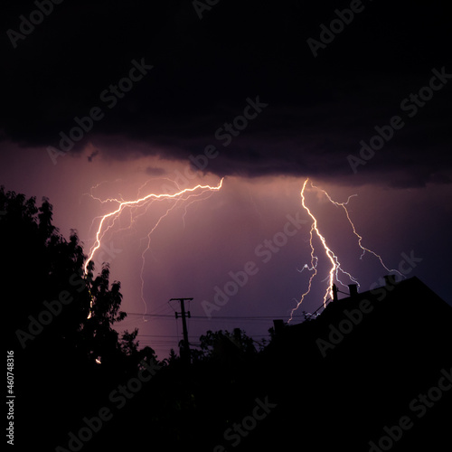 Multiple lightning strikes painting the sky purple on a summer evening during a thunderstorm