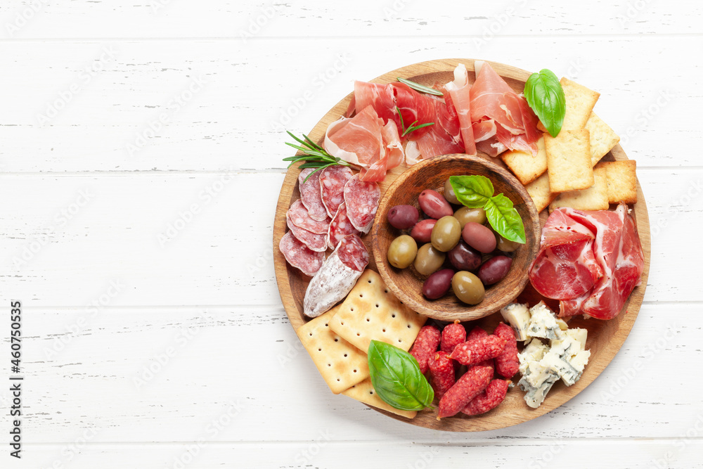 Antipasto board with prosciutto, salami, crackers, cheese, olives - obrazy, fototapety, plakaty 