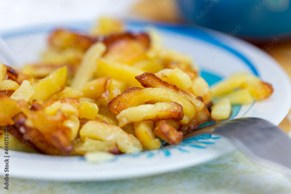 French fries on plate and fork, little left French fries on plate and fork, little left
