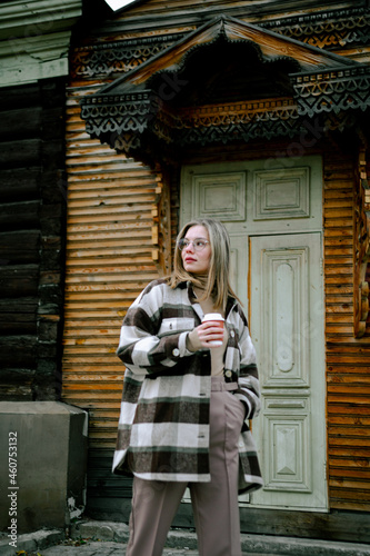 A girl with a cup of coffee in the autumn city