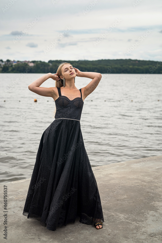 beautiful woman in black fashion dress posing near lake beautiful woman in black fashion dress posing near lake