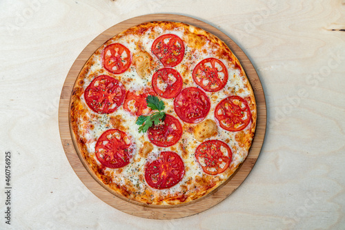 Tasty margarita pizza on a wooden background.