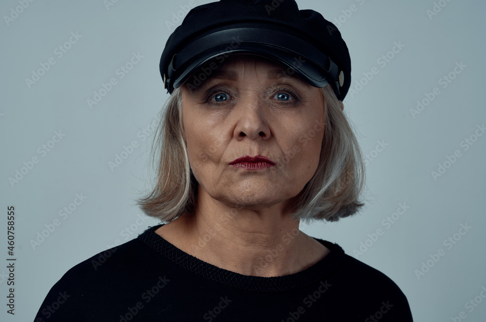 elderly woman in a black hat fashion close-up light background elderly woman in a black hat fashion close-up light background