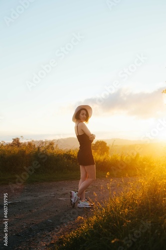 woman in a hat standing in a field and looking at a camera, space for text, atmospheric epic moment