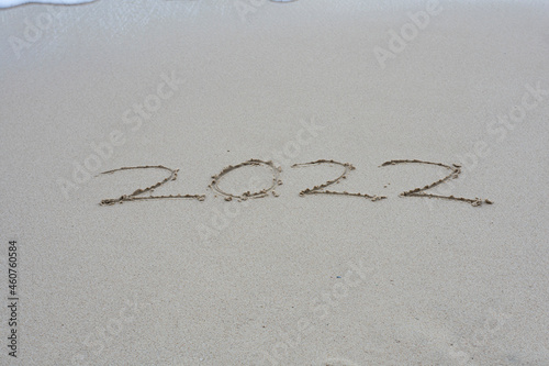 2022 written on the beach sand.