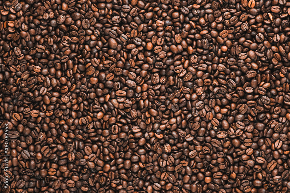 Roasted coffee beans spilled freely on a wooden table. Coffee beans background. Coffee break Roasted coffee beans spilled freely on a wooden table. Coffee beans background. Coffee break