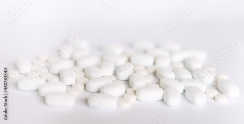 Many white pills on a white background. Health.