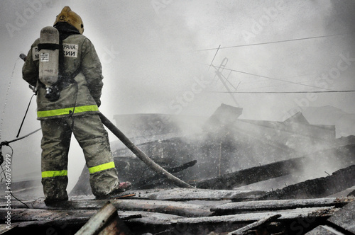 Firefighters extinguish a fire on the roof of a house on a frosty winter day