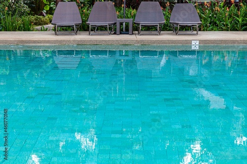 Wide swimming pool and brown stone floor inside the villa