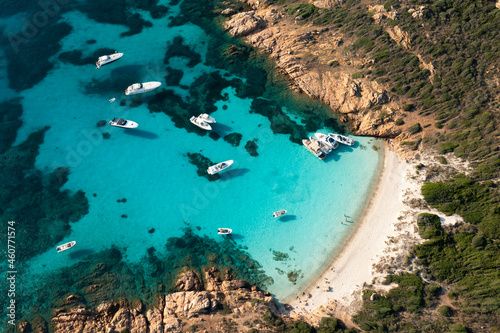 View from above, stunning aerial view of Mortorio island with a beautiful white sand beach and some boats and yachts floating on a turquoise, crystal clear water. Sardinia, Italy.