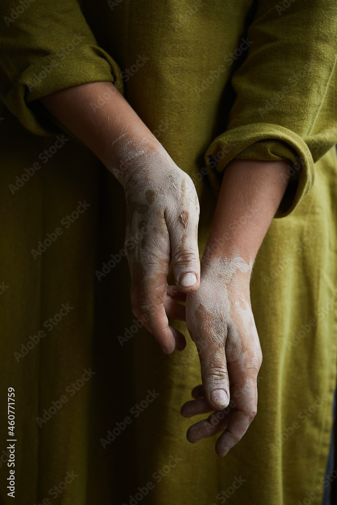 Fototapeta premium Close Up Of Ceramist's Hands Dirty Of Clay. Pottery studio The process of creating pottery. The master ceramist works in her studio
