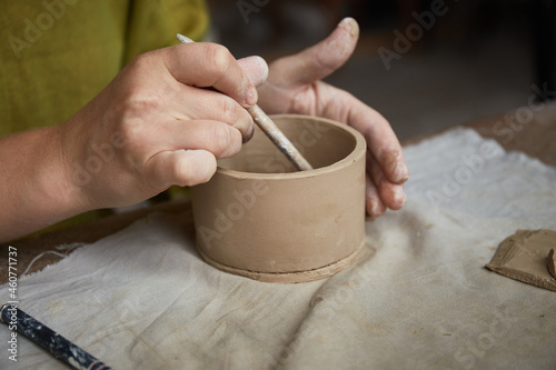 Female ceramist working in pottery studio. Ceramist's Hands Dirty Of Clay. Process of creating pottery. Master ceramist works in her studio