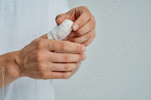 male patient in a white T-shirt with a bandaged hand hospital medicine