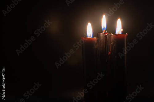 Black bleeding candles against black background