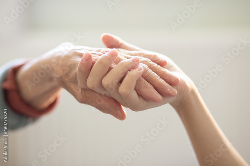 The hands of the child in the hands of the grandmother, the old brownish skin in the elderly woman, motherly love and care.