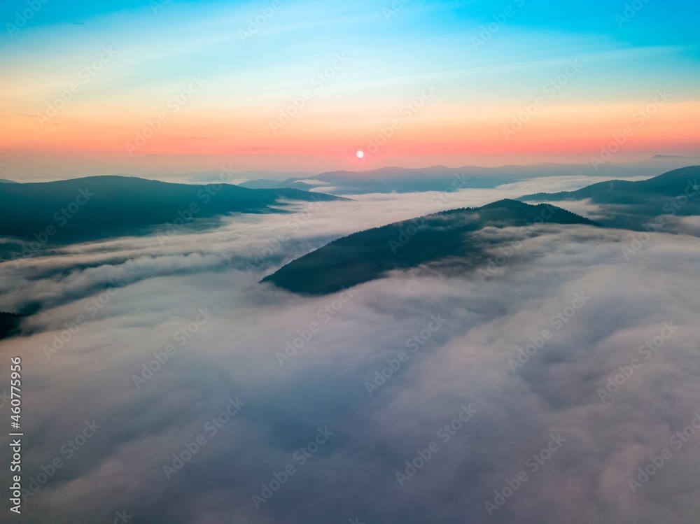 Fog in the mountain valley at dawn. Ukrainian Carpathians in the morning in the haze. Aerial drone view.