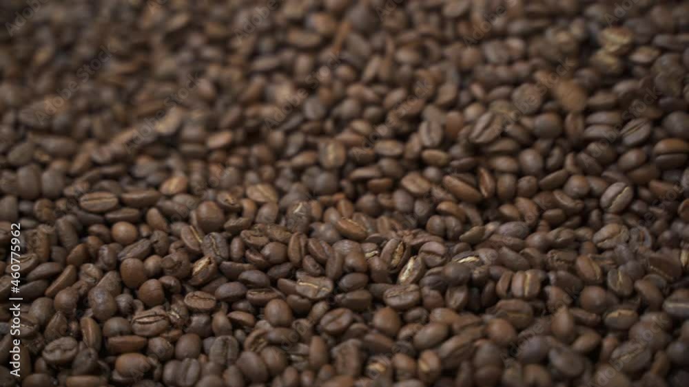 Closeup view of coffee beans is roasted and dried with using automatic equipment in plant spbas. Brown Arabica seeds are roasted, dried and rotated inside metal container to hot process natural coffee Closeup view of coffee beans is roasted and dried with using automatic equipment in plant spbas. Brown Arabica seeds are roasted, dried and rotated inside metal container to hot process natural coffee