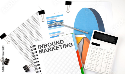 Text INBOUND MARKETING on a notebook on the diagram and charts with calculator and pen © Iryna
