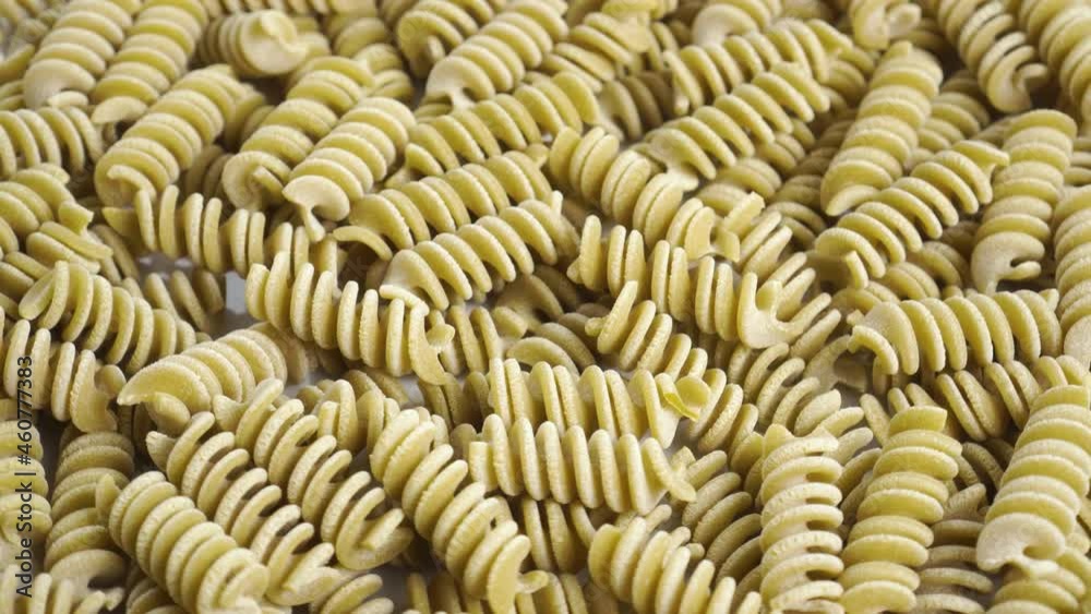 Fusilli Italian uncooked pasta. Green pea vegetable spiral macaroni. Macro. Mediterranean cuisine concept. Rotation